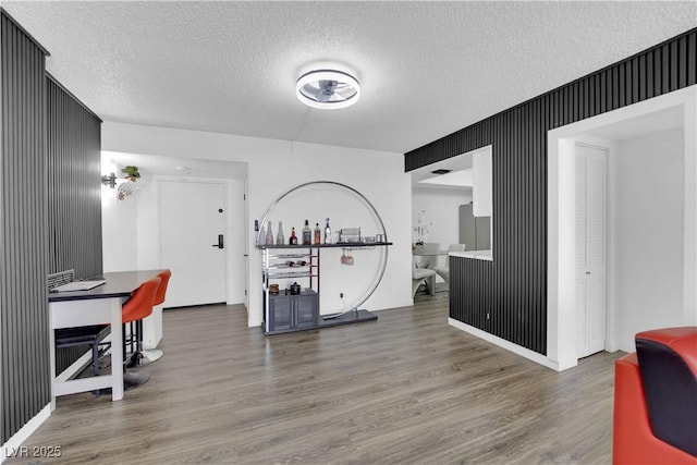 interior space with a textured ceiling and wood finished floors
