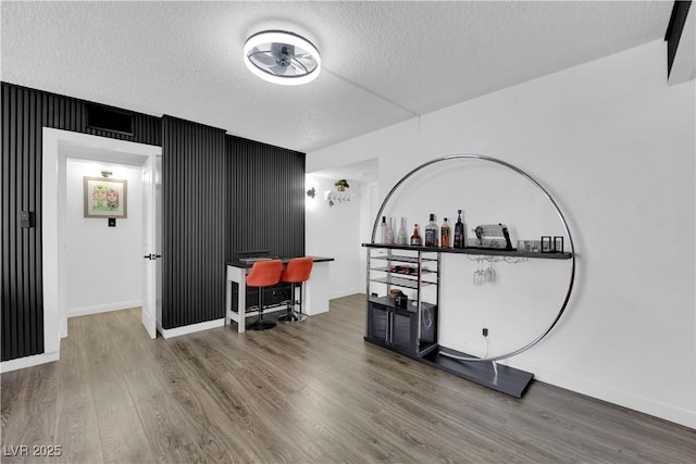 misc room with baseboards, wood finished floors, and a textured ceiling