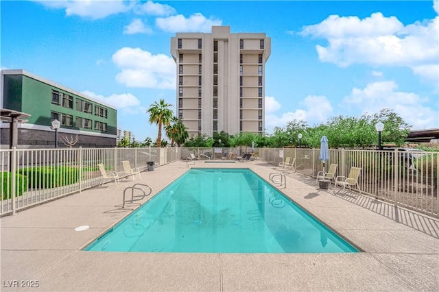 pool with a patio area and fence