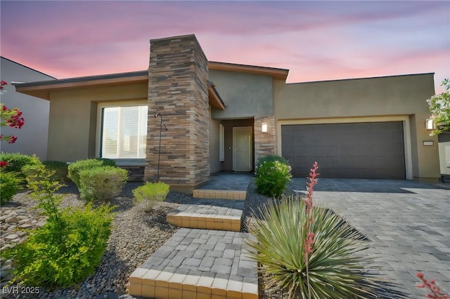 10348 Bressana Dr, Las Vegas, NV 89135 - view of front of home with stucco siding, an attached garage, and decorative driveway