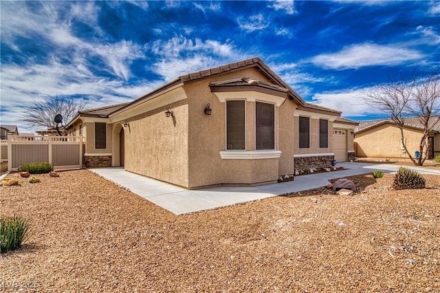 3891 Sedgwick, Pahrump, NV 89061 - back of house with stucco siding, a garage, fence, and stone siding