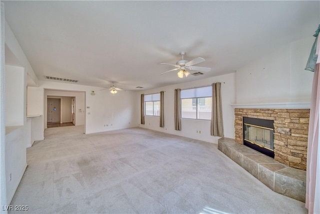 3891 Sedgwick, Pahrump, NV 89061 - unfurnished living room with light colored carpet, visible vents, ceiling fan, and a fireplace
