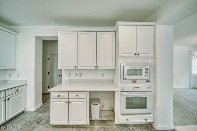 3891 Sedgwick, Pahrump, NV 89061 - kitchen with baseboards, white cabinetry, light countertops, and white appliances
