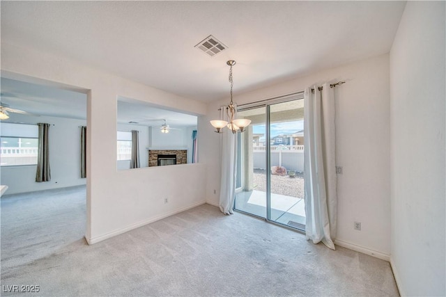 3891 Sedgwick, Pahrump, NV 89061 - unfurnished room with visible vents, a glass covered fireplace, light colored carpet, and ceiling fan
