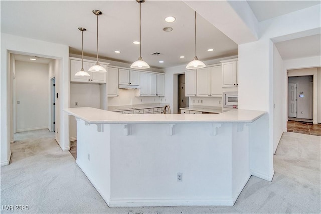 3891 Sedgwick, Pahrump, NV 89061 - kitchen featuring light colored carpet, recessed lighting, a kitchen breakfast bar, and white microwave