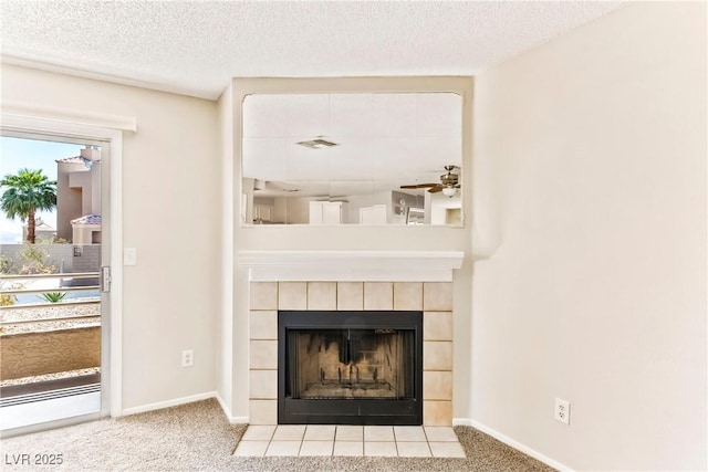 room details featuring carpet, a ceiling fan, baseboards, a tiled fireplace, and a textured ceiling