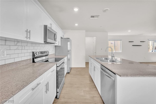 6952 Crimson Shadow St, North Las Vegas, NV 89086 - kitchen featuring appliances with stainless steel finishes, a sink, a center island with sink, white cabinets, and recessed lighting