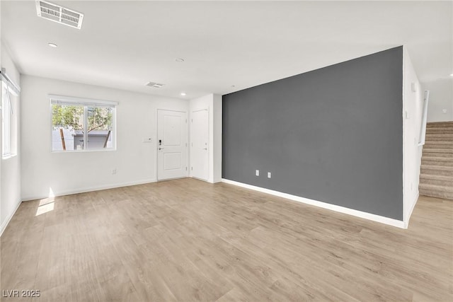 unfurnished living room with light wood finished floors, stairway, baseboards, and recessed lighting