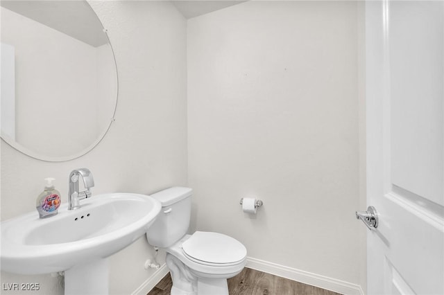 6952 Crimson Shadow St, North Las Vegas, NV 89086 - half bathroom featuring wood finished floors, baseboards, a sink, and toilet