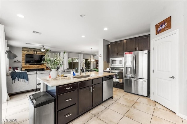 kitchen with open floor plan, light tile patterned floors, stainless steel appliances, a sink, and visible vents