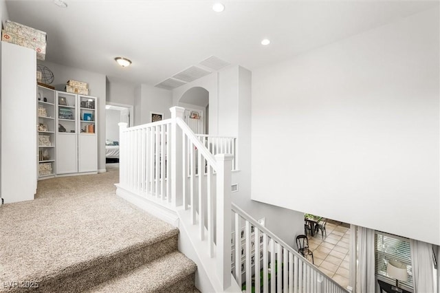 staircase with carpet floors, arched walkways, and recessed lighting