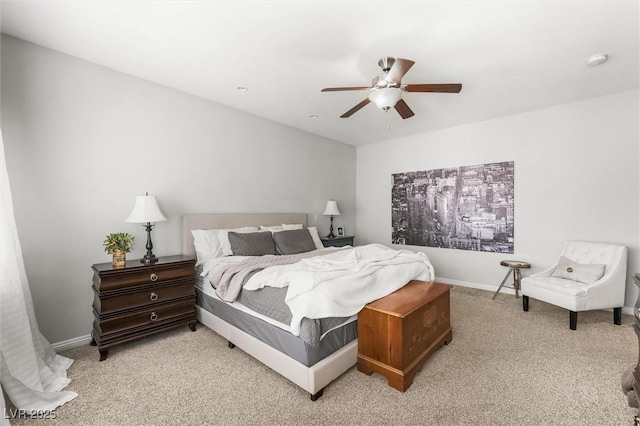 bedroom with baseboards, a ceiling fan, and light carpet