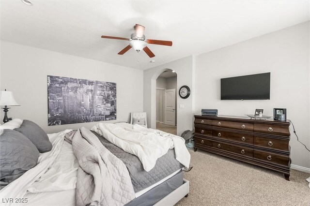 bedroom featuring arched walkways, carpet floors, and ceiling fan