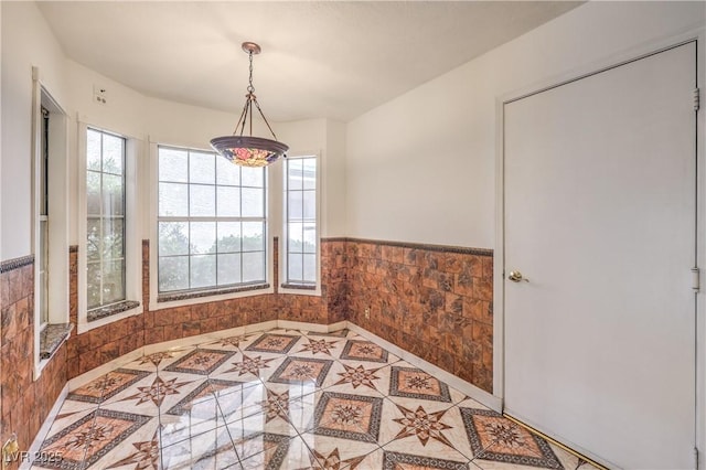 dining room featuring wainscoting and tile patterned flooring