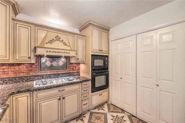 kitchen featuring black microwave, cream cabinetry, gas stovetop, and custom exhaust hood