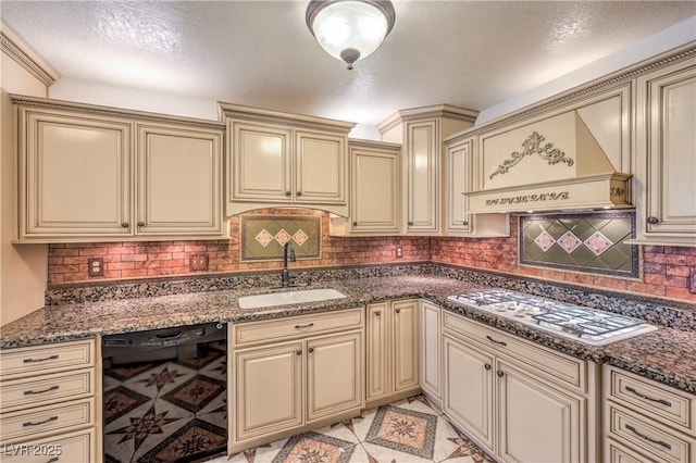 kitchen with gas cooktop, custom range hood, cream cabinets, a sink, and black dishwasher