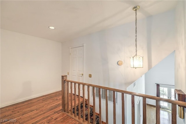 hall featuring an upstairs landing, wood finished floors, baseboards, visible vents, and recessed lighting