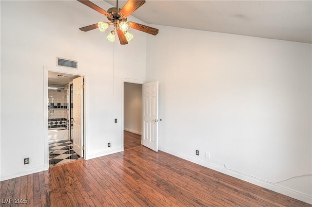 unfurnished bedroom featuring high vaulted ceiling, baseboards, connected bathroom, visible vents, and wood finished floors