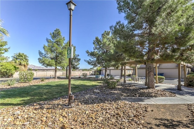 surrounding community featuring a yard, a pergola, and fence