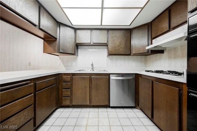 kitchen with light countertops, dark brown cabinets, dishwasher, white gas cooktop, and a sink