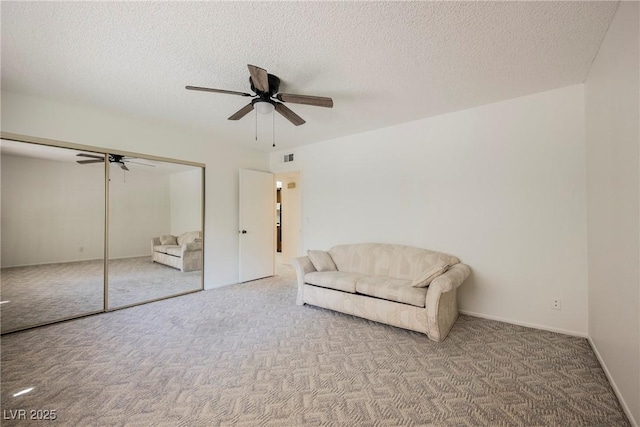 sitting room featuring ceiling fan, a textured ceiling, and carpet flooring