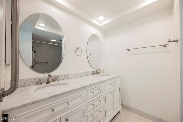 bathroom with baseboards, recessed lighting, double vanity, and a sink