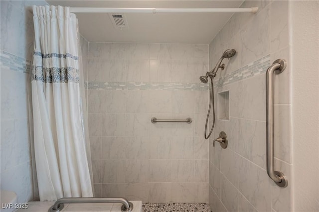 bathroom with a stall shower and visible vents