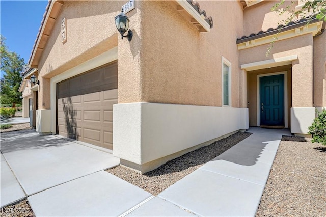 6656 Fort William St, North Las Vegas, NV 89084 - view of exterior entry with stucco siding, concrete driveway, and an attached garage