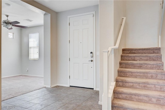 6656 Fort William St, North Las Vegas, NV 89084 - foyer entrance with light carpet, ceiling fan, light tile patterned floors, stairway, and baseboards