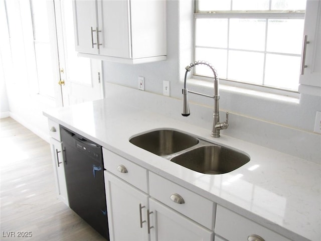 861 Mcmurray Dr, Pahrump, NV 89060 - kitchen with black dishwasher, a sink, light stone counters, light wood finished floors, and white cabinets