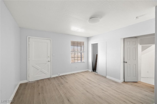861 Mcmurray Dr, Pahrump, NV 89060 - unfurnished bedroom with baseboards, a closet, light wood-style flooring, and a textured ceiling
