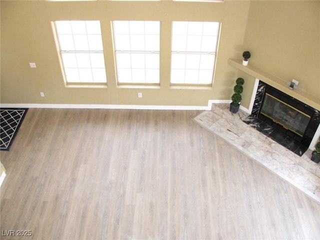 861 Mcmurray Dr, Pahrump, NV 89060 - unfurnished living room featuring baseboards, a glass covered fireplace, and wood finished floors