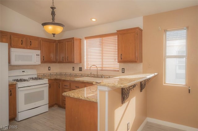 9323 W Rochelle Ave, Las Vegas, NV 89147 - kitchen featuring white appliances, a peninsula, a sink, light stone counters, and decorative light fixtures