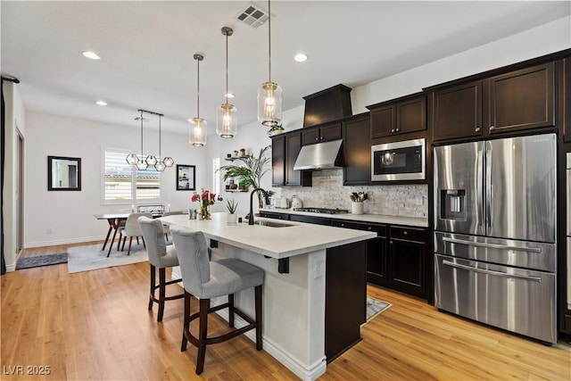11834 Albissola Ave, Las Vegas, NV 89138 - kitchen featuring a sink, tasteful backsplash, under cabinet range hood, stainless steel appliances, and visible vents