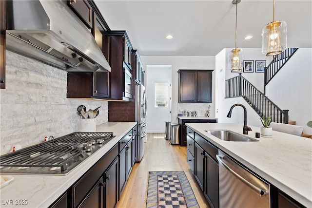 11834 Albissola Ave, Las Vegas, NV 89138 - kitchen with light wood-type flooring, stainless steel appliances, under cabinet range hood, hanging light fixtures, and a sink