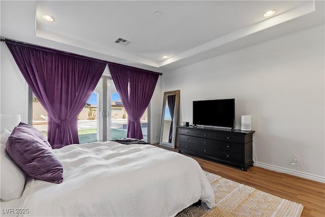 11834 Albissola Ave, Las Vegas, NV 89138 - bedroom featuring visible vents, baseboards, wood finished floors, a raised ceiling, and access to exterior