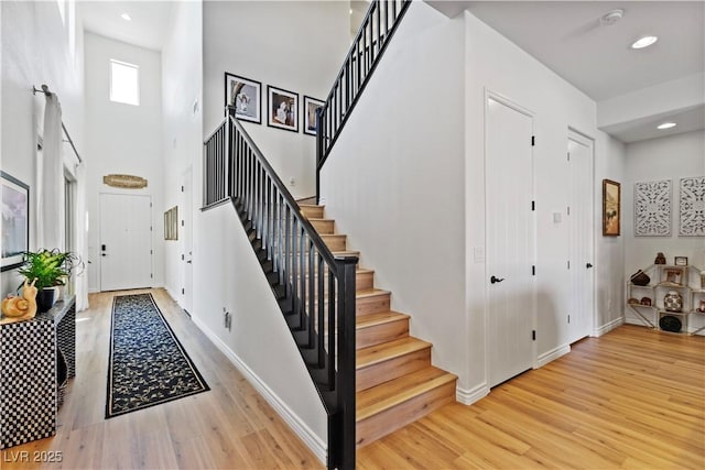 11834 Albissola Ave, Las Vegas, NV 89138 - foyer featuring baseboards, light wood-style flooring, a towering ceiling, and stairway