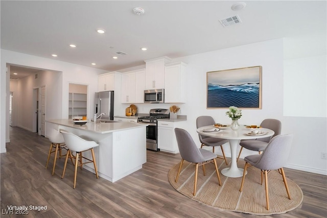 600 N Carriage Hill Dr Unit 2174, Las Vegas, NV 89138 - kitchen featuring stainless steel appliances, a sink, an island with sink, dark wood-style floors, and white cabinets