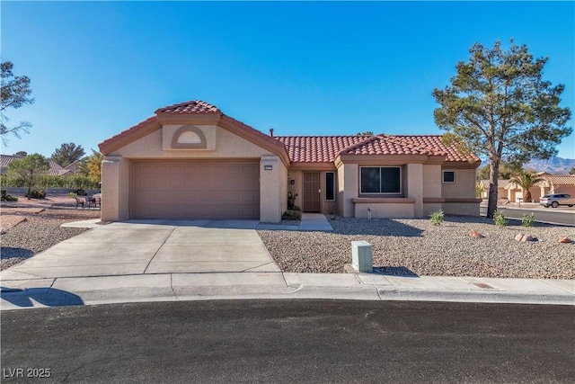 mediterranean / spanish-style home featuring concrete driveway, a tiled roof, stucco siding, and an attached garage