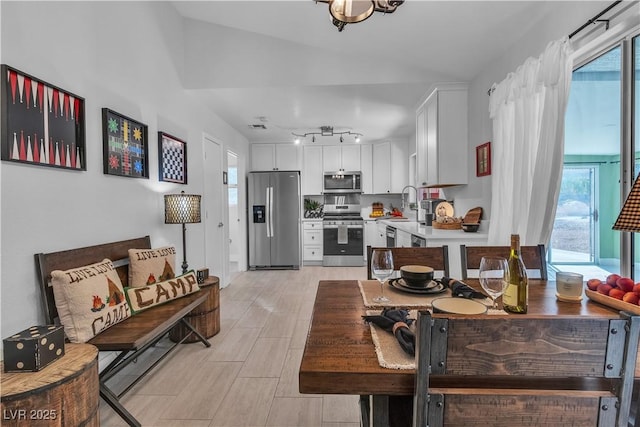 dining room featuring lofted ceiling, light wood-style floors, and visible vents