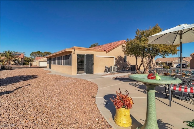 rear view of property with stucco siding and a tile roof