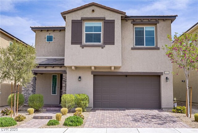 8564 Scalpay St, Las Vegas, NV 89166 - view of front facade with stucco siding, a garage, decorative driveway, and stone siding