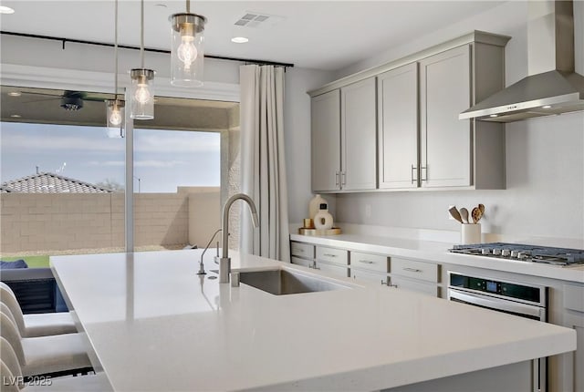 8564 Scalpay St, Las Vegas, NV 89166 - kitchen featuring wall chimney exhaust hood, gray cabinets, stainless steel gas stovetop, a sink, and recessed lighting