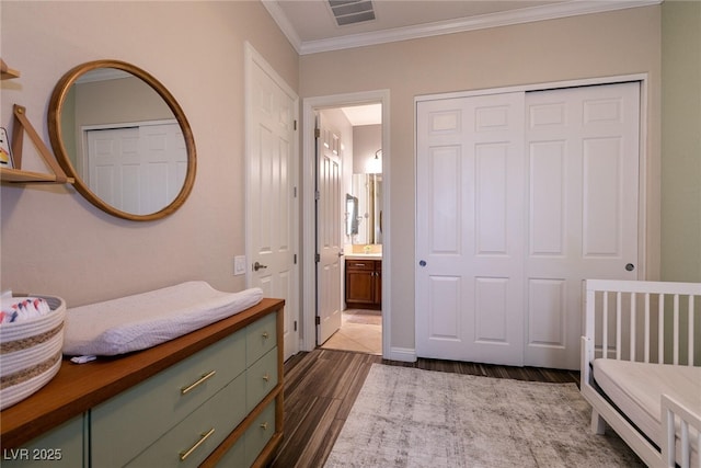 3920 Eiderdown Pl, North Las Vegas, NV 89084 - bedroom featuring a closet, ornamental molding, visible vents, connected bathroom, and dark wood-style floors