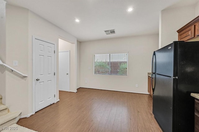 kitchen with light wood finished floors, recessed lighting, visible vents, and freestanding refrigerator