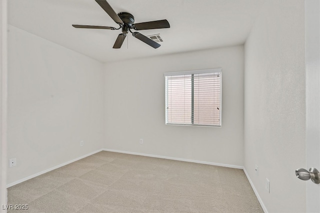 spare room featuring light colored carpet, visible vents, ceiling fan, and baseboards