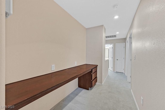 hallway featuring light colored carpet, visible vents, recessed lighting, and baseboards