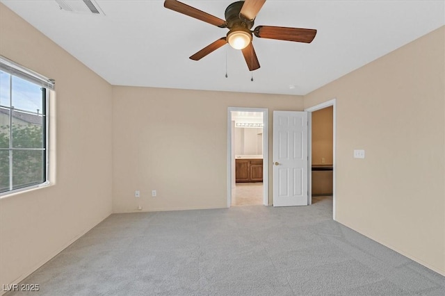 spare room with a ceiling fan, visible vents, and light carpet