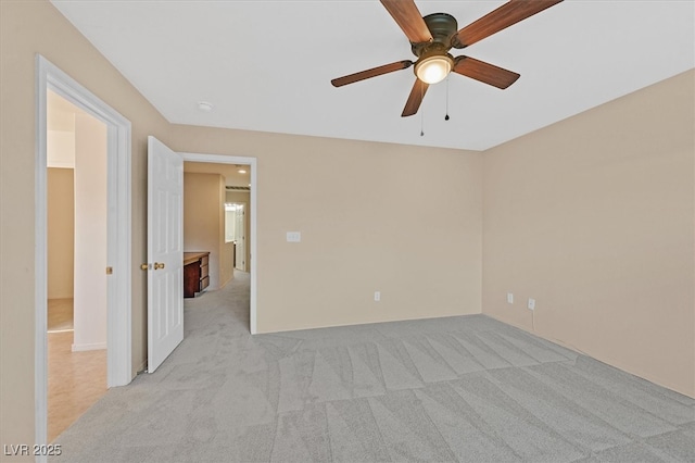 empty room with light colored carpet and a ceiling fan