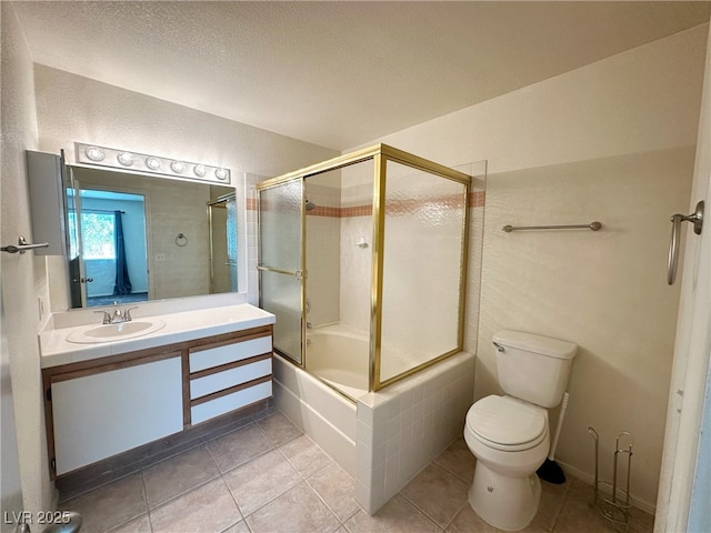 bathroom with tile patterned floors, combined bath / shower with glass door, toilet, vanity, and a textured ceiling